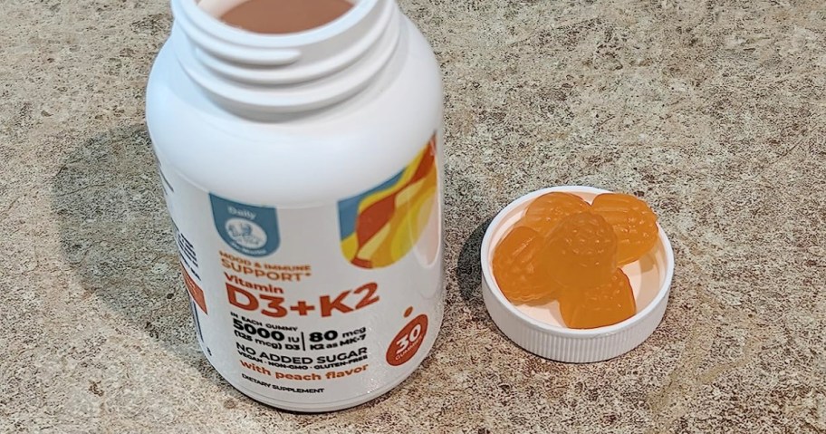 DR. MORITZ Vitamin D3 K2 Gummies bottle with the lid of next to it and gummies in the lid