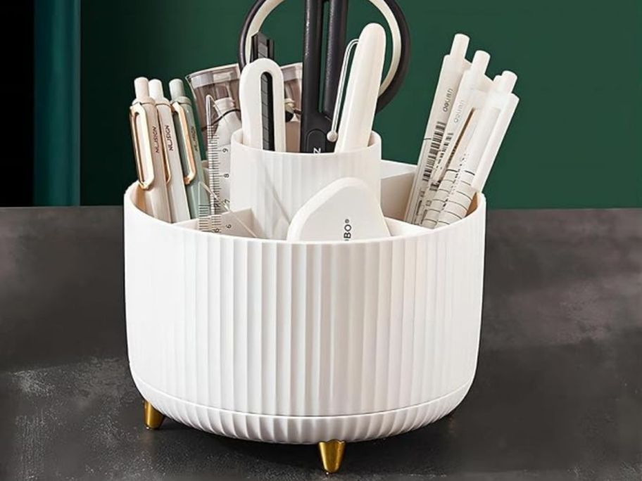 Dasiton Large Capacity Rotating Makeup Brush Organizer in White on table with office supplies in it