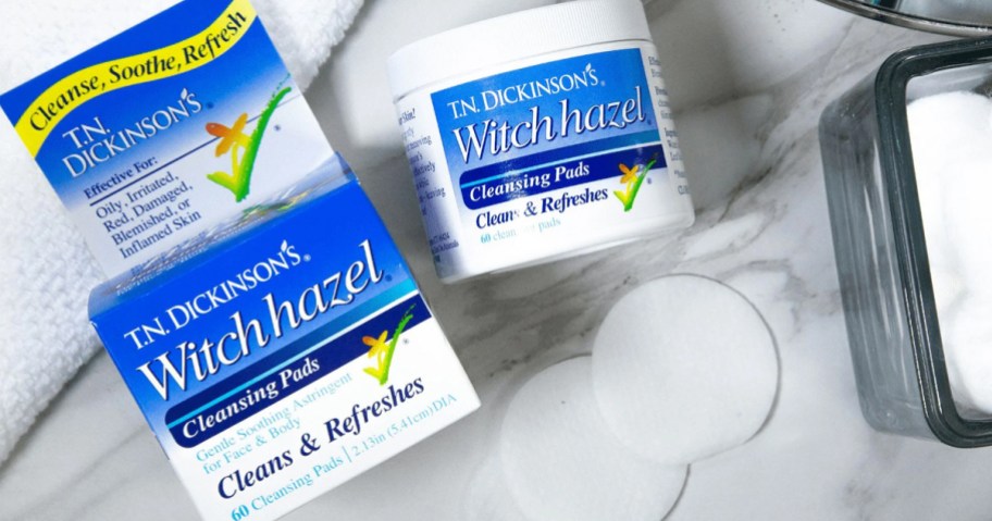 jar and box of Dickinson's Witch Hazel Cleansing Pads with two pads near them on bathroom counter