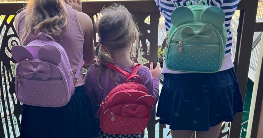 3 girls wearing Disney backpacks