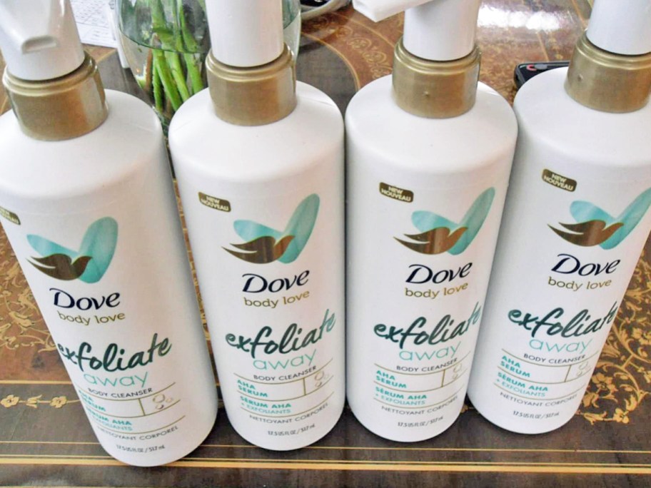 four white bottles of Dove Body Love Exfoliate Away Cleansers