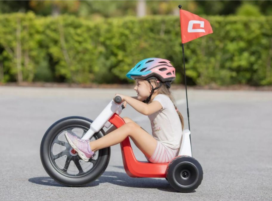 a little kid wearing a helmet and riding an electric trike