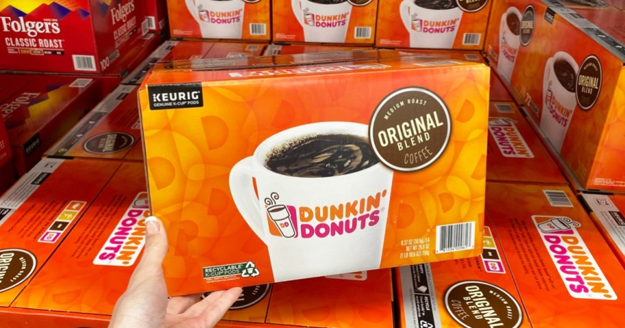 hand holding a large orange box of dunkin k-cups