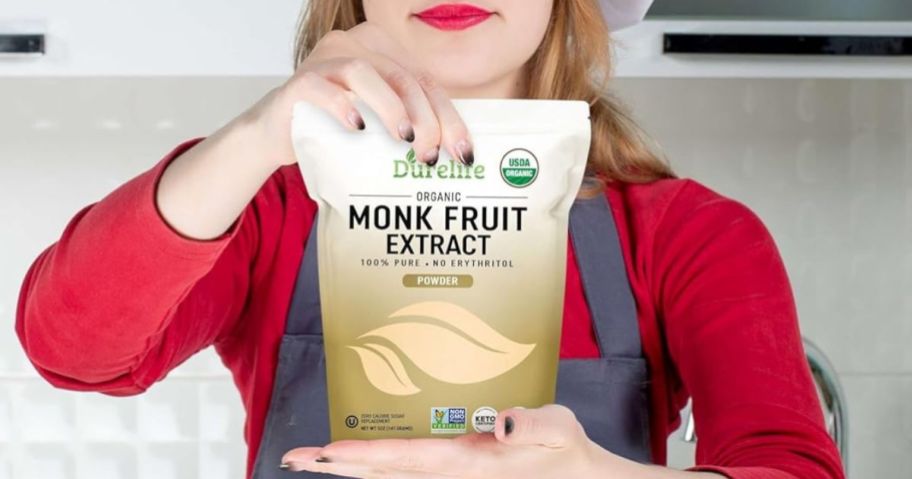Woman wearing an apron and holding a bag of Durelife Monkfruit Extract Powder