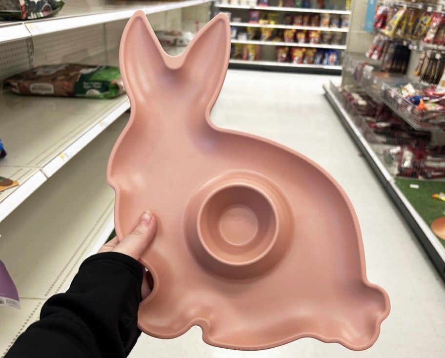 hand holding up a pink bunny-shaped easter serving plate