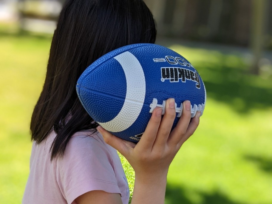 child holding Franklin Sports Grip-Rite Junior Football in Blue