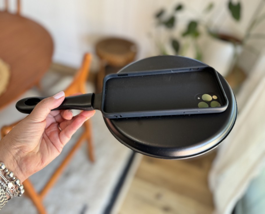 Hand holding up a frying pan phone case which makes an excellent gag gift or April Fools Day prank