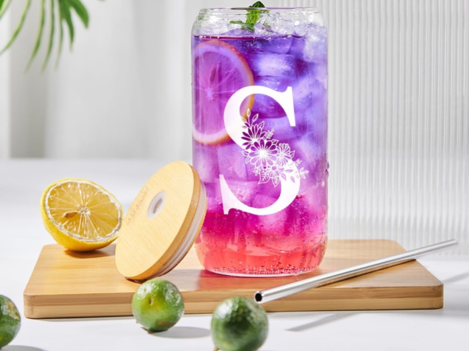 Glass cup with initals with purple drink inside and limes on it
