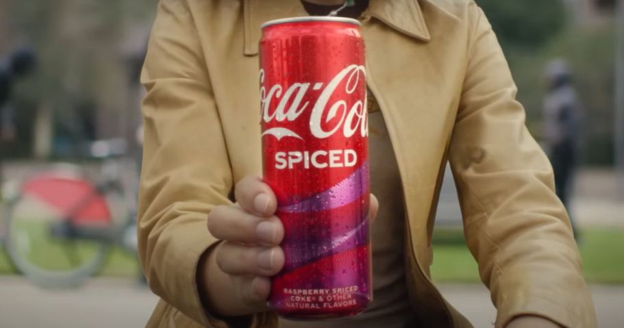 man holding a Coca Cola Spiced can up to the camera