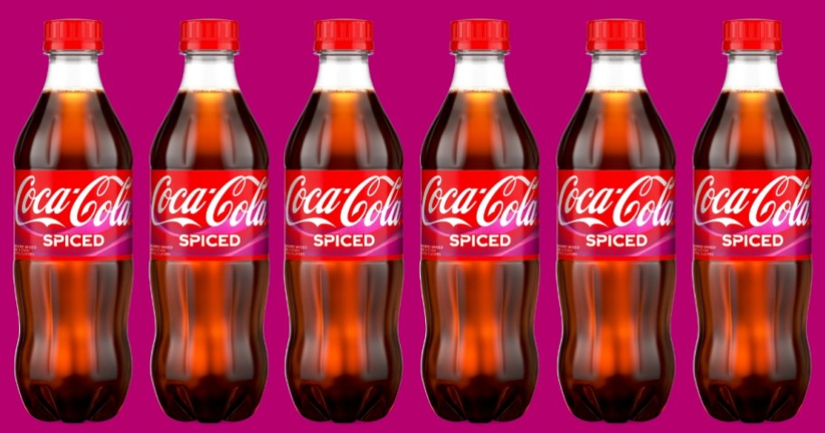 6 bottles of Coca-Cola Spiced soda on a purple background
