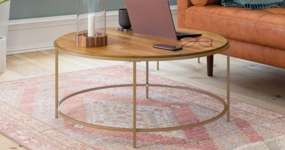large round wood top and metal base coffee table in a living room