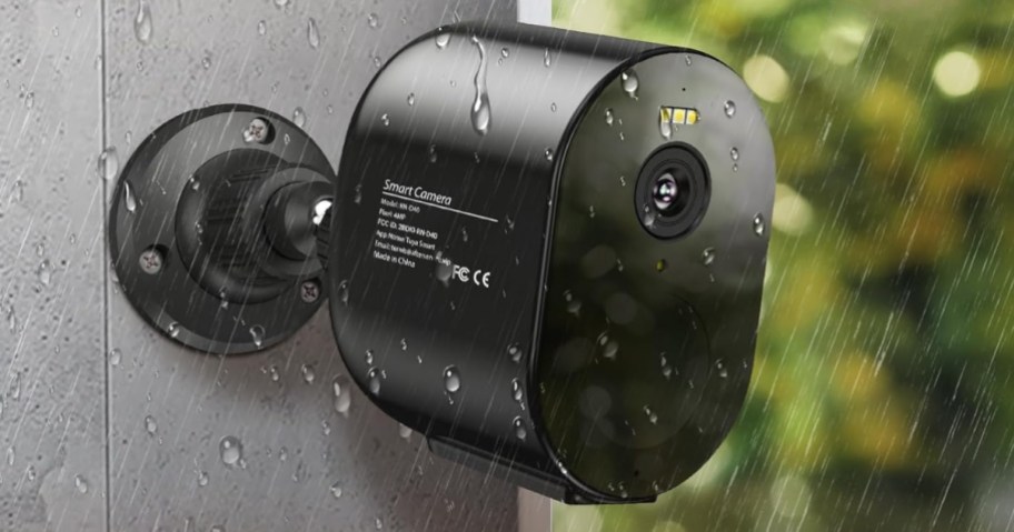 black TENVIS brand Security Camera attached to an exterior wall with rain coming down around it