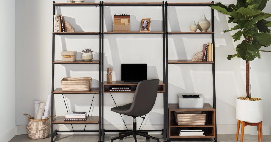 leaning ladder style desk and bookcases with a laptop, books, printer and other decor