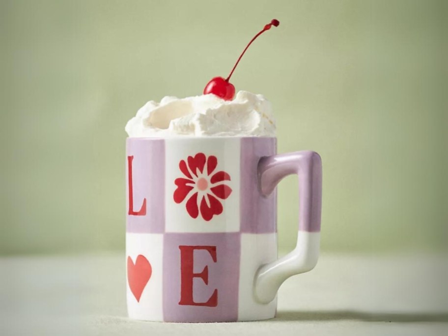 purple and white checkered mug with LOVE written on it, cream and cherry on top