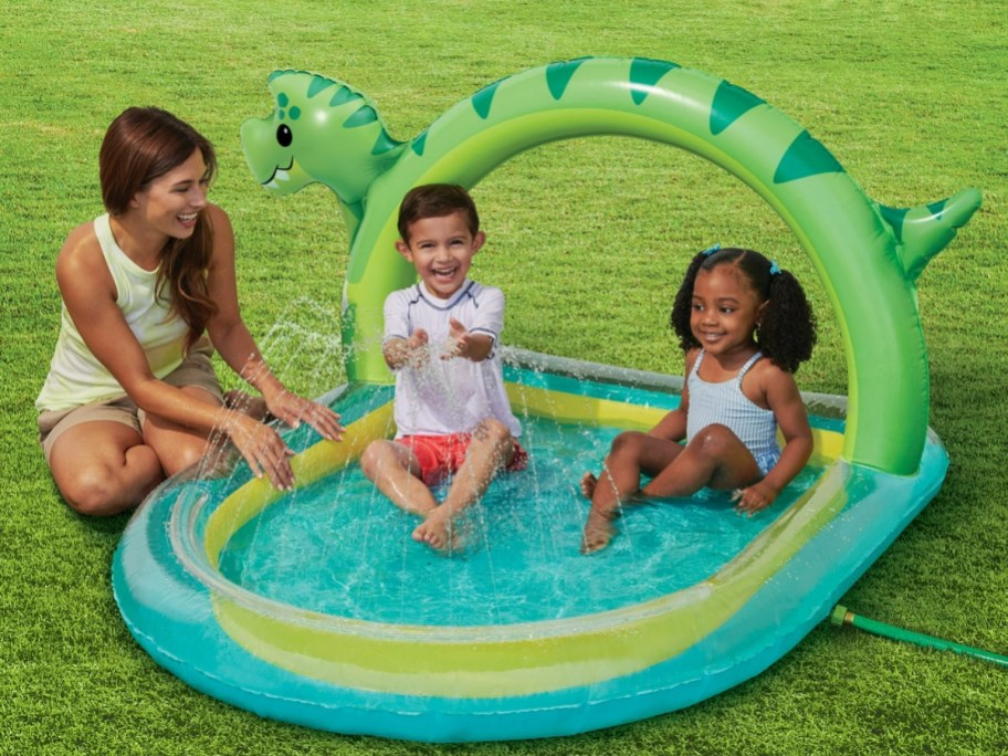 kids playing in a dinosaur arch inflatable pool