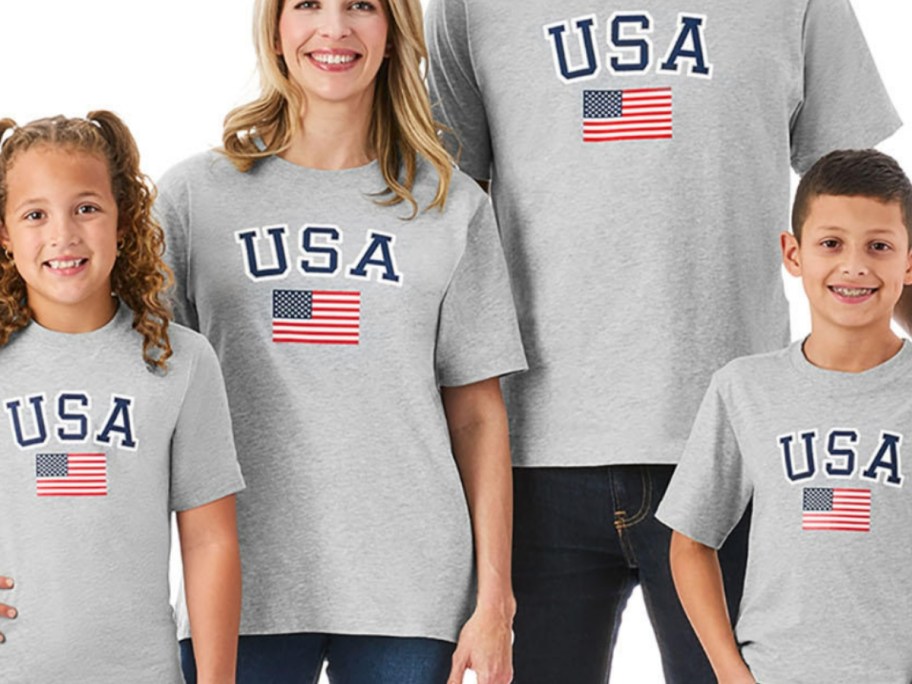 family with kids and adults wearing grey t-shirts that have "USA" and an American flag on them