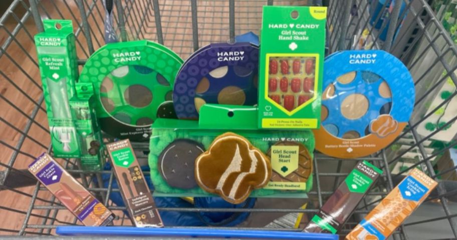 a shopping cart front basket filled with items from the hard candy girl scout makeup collection