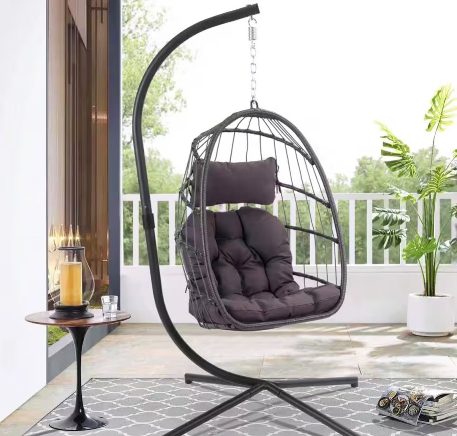 egg chair with grey cushions hanging from stand on patio