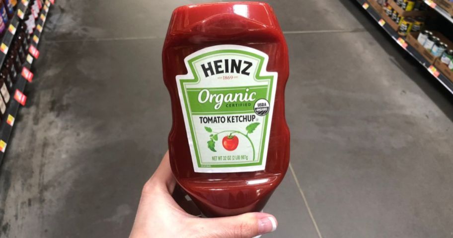 Hand holding a bottle of Heinz Organic Tomato Ketchup
