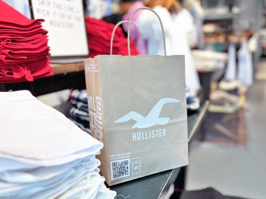 A hollister shopping bag on a store display table