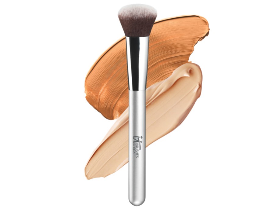 IT Cosmetics makeup brush with makeup in the background