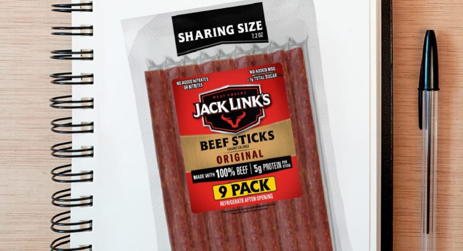 Jack links beef sticks 9 pack displayed on a notebook with a pen next to it
