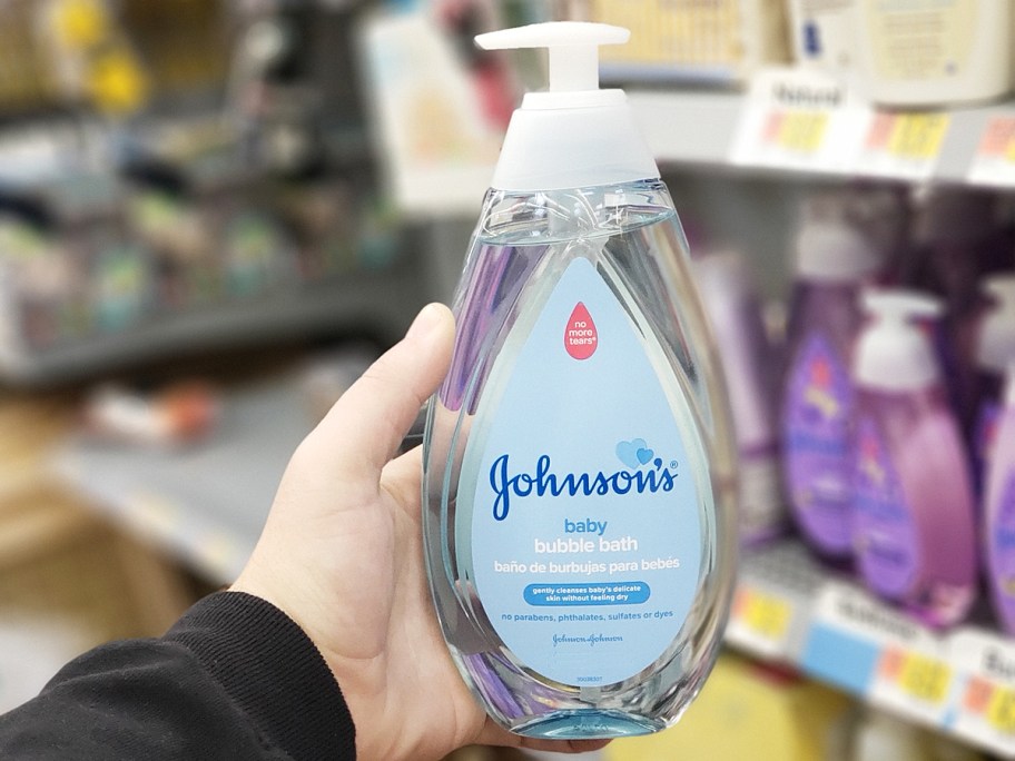 hand holding a large blue bottle of Johnson's Baby Bubble Bath