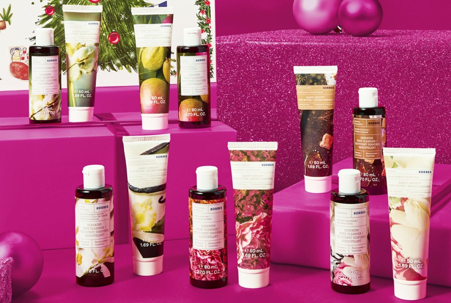 sets of holiday themed cleansers and body butters on a pink background with ornaments