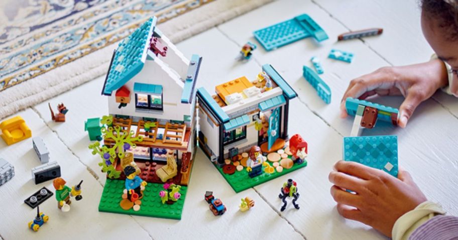 a little girl building a lego house kit