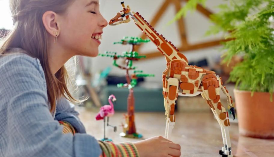 a little girl playing with the LEGO Creator Wild Safari Animals 3-in-1 Set.