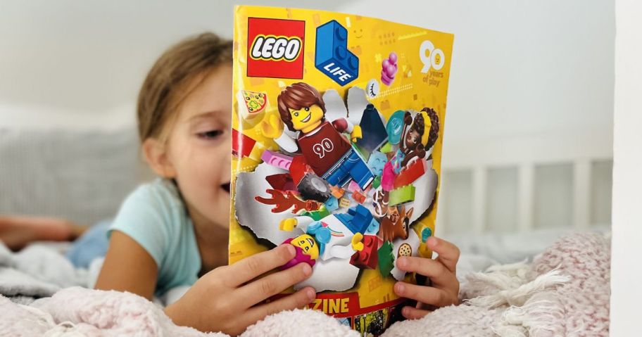 Little girl holding a LEGO Life magazine