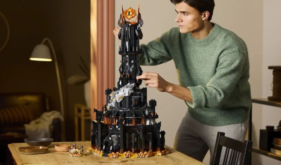 a man building a lego lord of the rings barad dur tower