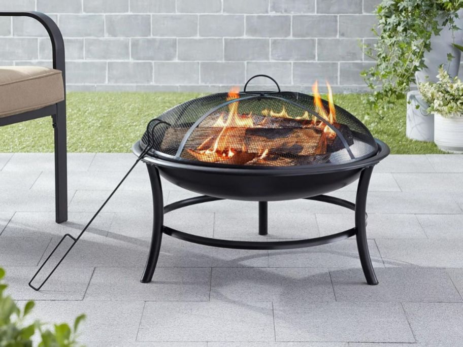 Mainstays 26" Metal Round Iron Outdoor Wood-Burning Fire Pit on a patio
