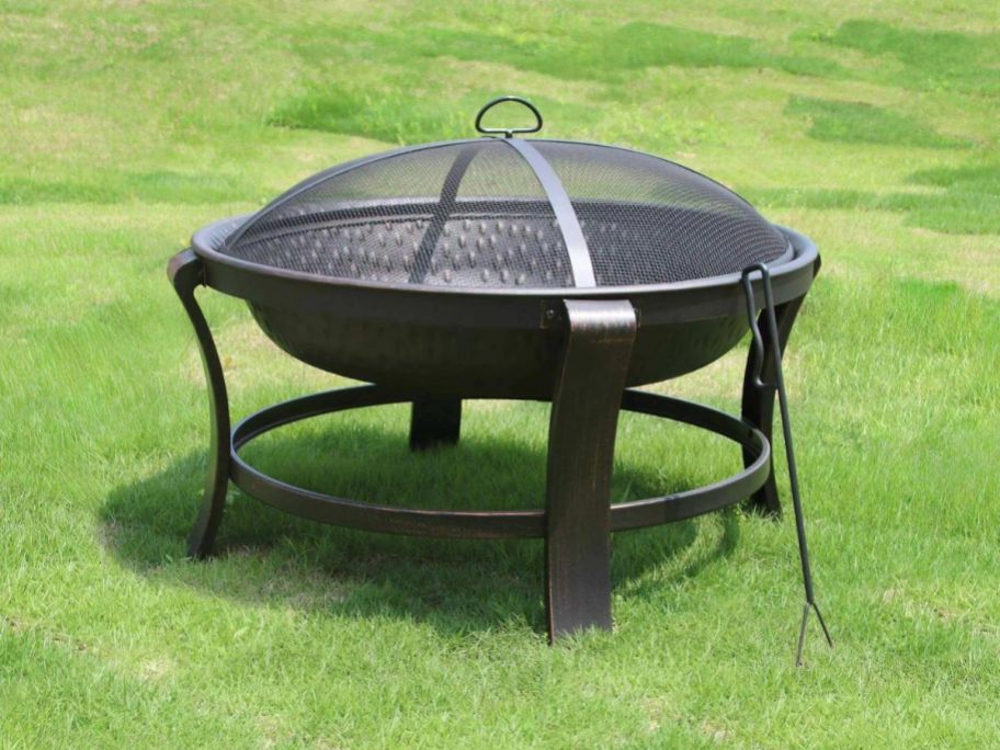 A Mainstays Deep 30" Steel Fire Pit in Antique Bronze on the lawn