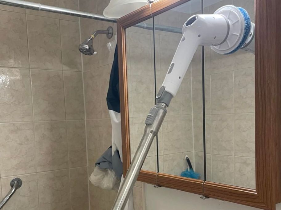 A maxtopfit scrubber being used to clean a bathroom mirror