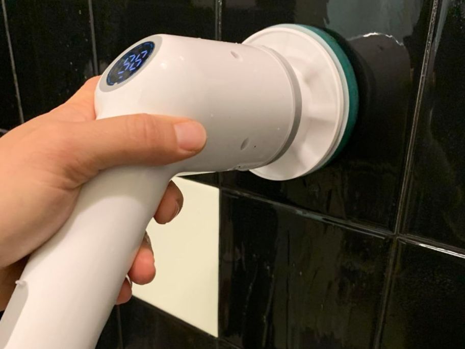 hand using a maxtopfit scrubber to clean bathroom tile