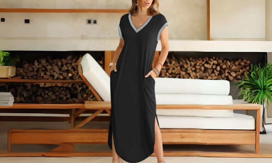 a woman wearing a nave blue short sleeve maxi dres standing in front of a white chaise lounge