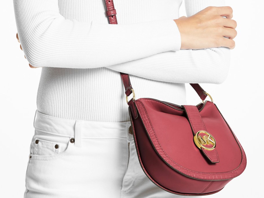 woman in an all white outfit with a maroon Michael Kors crossbody bag