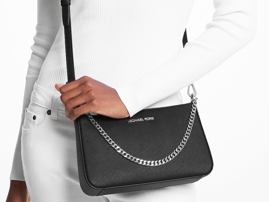 woman in white outfit with black crossbody bag with silver chain