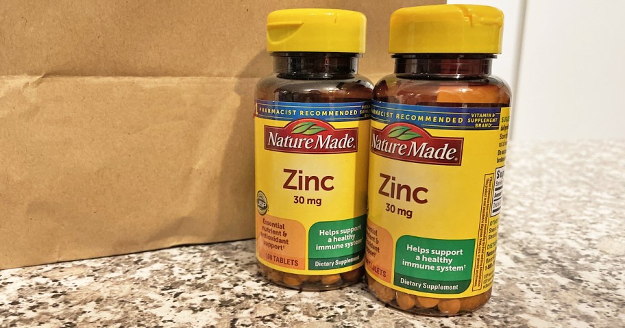 two bottles of Nature Made Zinc on counter near brown bag
