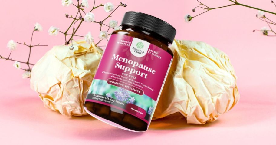 bottle of Nature's Craft Soy Free Menopause Support supplements laying against flowers