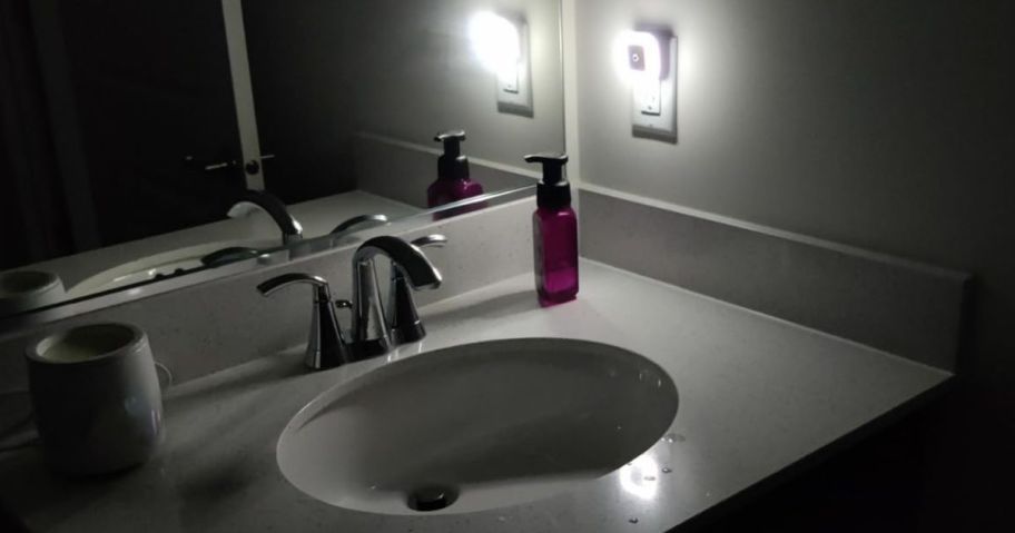 A bathroom in the dark with a bright nigh light