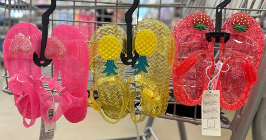 3 pairs of Old Navy Toddler Jelly Sandals hanging on a shopping cart