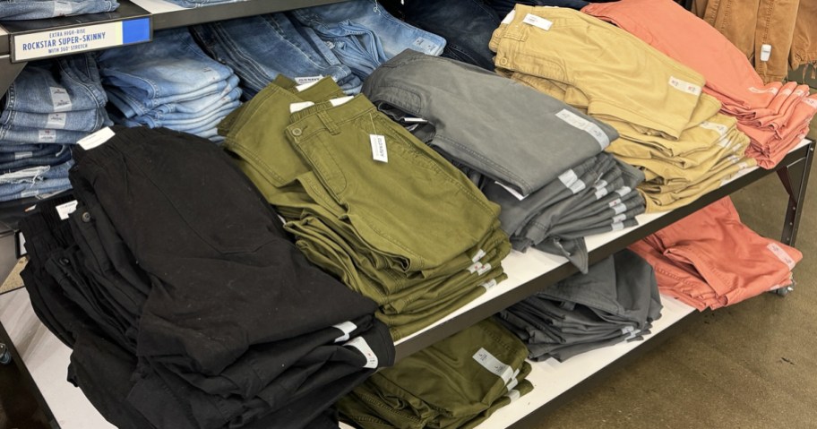 display table full of folded pants in various colors