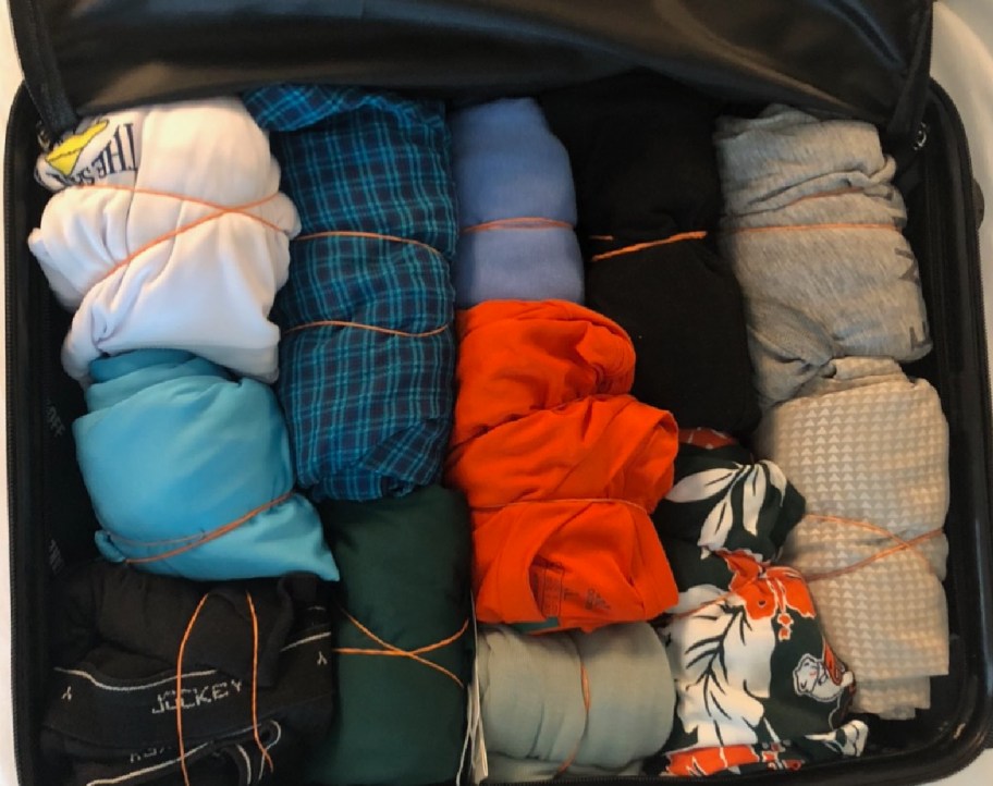 Happy Friday reader's packed suitcase with clothes rolled and rubberbanded
