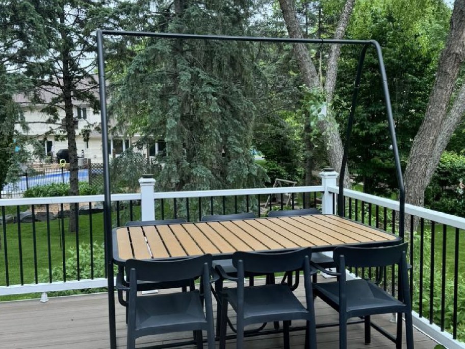 Pergola table with chairs displayed outside on a deck
