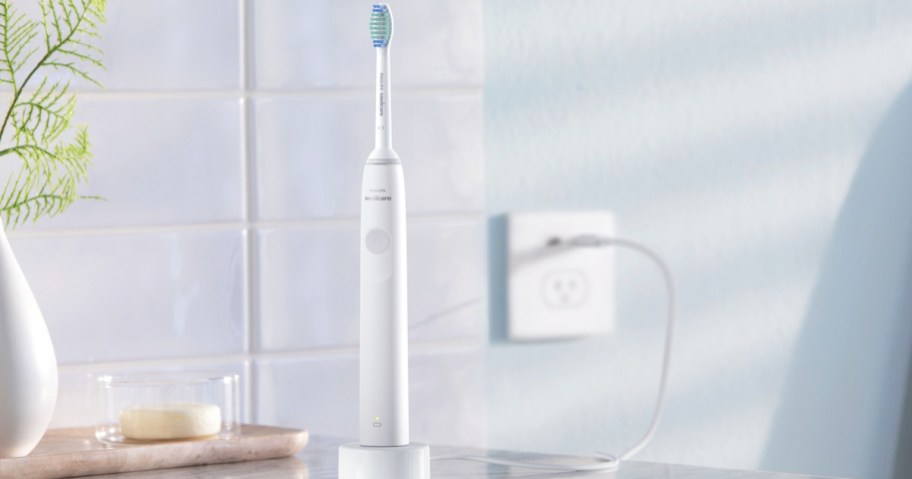 white electric toothbrush on charger on bathroom counter