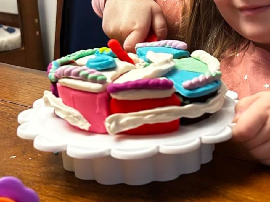 girl slicing cake creation made from the Play-Doh Oven Bakery Super Slice Cake Playset