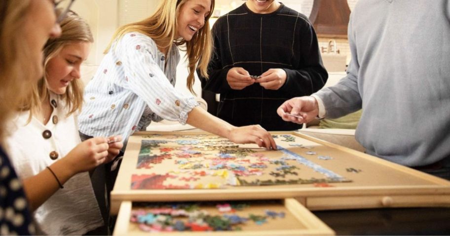 People doing a puzzle on a Playvibe Jigsaw Puzzle Table