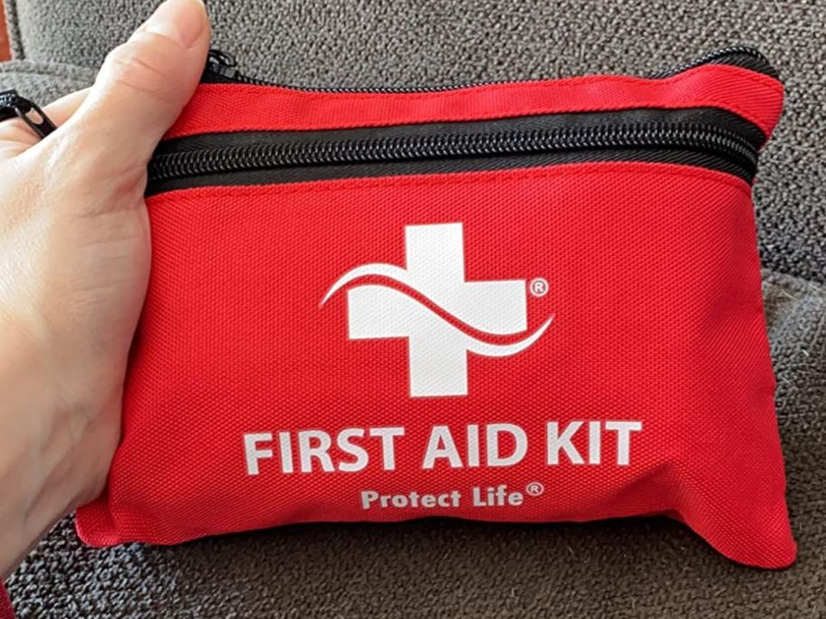 hand holding a small Protect Life First Aid kit